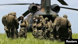 2013年7月8日﹐日本陸上自衛隊第1空降旅的士兵準備登上一架CH-47型直升機在西東京裾野市進行降落傘降訓練。
