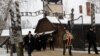 FILE - People arrive to lay wreaths at the "death wall" at the former Nazi German concentration and extermination camp Auschwitz, during the ceremonies marking the 74th anniversary of the liberation of the camp and International Holocaust Victims Remembrance Day