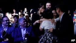 Members of Kitkit School embrace after winning the XPRIZE for Children's Literacy, Wednesday, May 15, 2019, in Los Angeles. (AP Photo/Marcio Jose Sanchez)