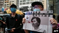 2019年8月31日，在“为香港罪人祈祷”游行期间，一名示威者在铜锣湾展示一张香港行政长官林郑月娥溅血的海报。