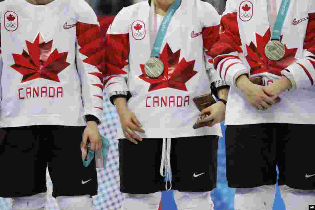 Jocelyne Larocque, of Canada, at left, holds her silver medal after losing to the United States in the women's gold medal hockey game at the 2018 Winter Olympics in Gangneung, South Korea, Feb. 22, 2018. 