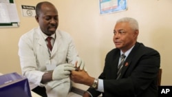 United States Ambassador to Zimbabwe, Charles A. Ray, right, takes an HIV test in Harare, December 1, 2010.