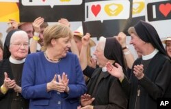 German Chancellor and top candidate of the Christian Democratic, Angela Merkel gains support from nuns during a campaign appearance in Delbrueck, Sept. 10, 2017.