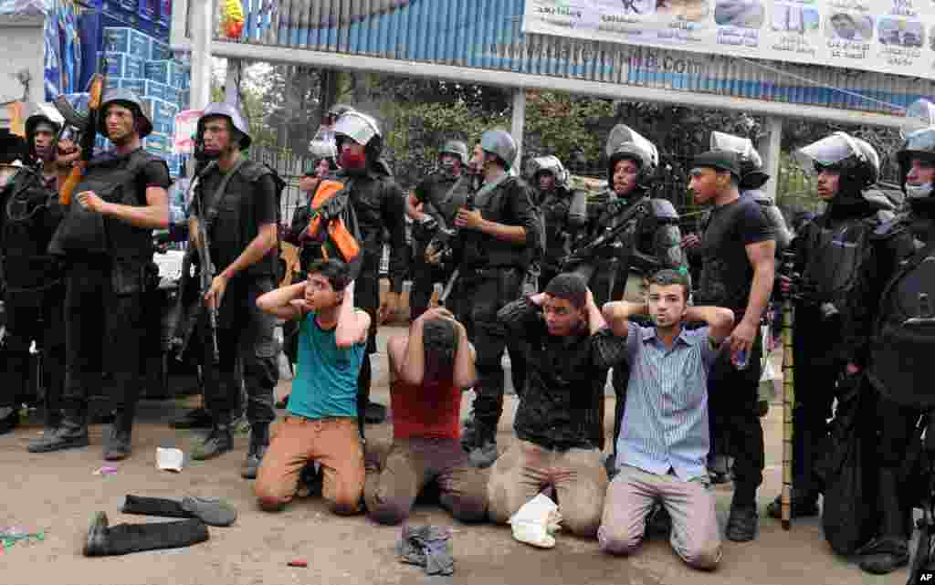 Egyptian security forces detain supporters of ousted President Mohamed Morsi as they clear a sit-in camp set up near Cairo University in Cairo's Giza district, Egypt, Aug. 14, 2013.