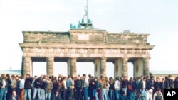 Berlin, 10 noyabr 1989-cu il -Şərqi və Qərbi almanlar Brandenburq qapısı qarşısında Berlin divarı üzərində dayanıb.