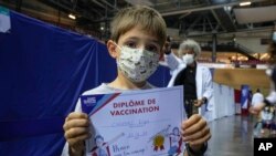 Hugo Chappaz, 9, displays his vaccination diploma at the National Velodrome in Saint-Quentin-en-Yvelines, west of Paris, France, Dec. 22, 2021. 