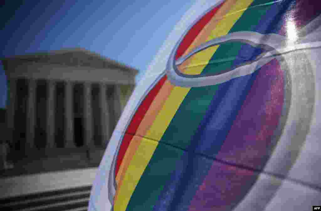 An activist flies a "marriage pride flag" outside the U.S. Supreme Court in Washington, D.C. The justices of the Supreme Court were scheduled to meet to determine whether the court will take up any of the five pending state-banned same-sex marriage cases in Ohio, Tennessee, Michigan, Kentucky and Louisiana.