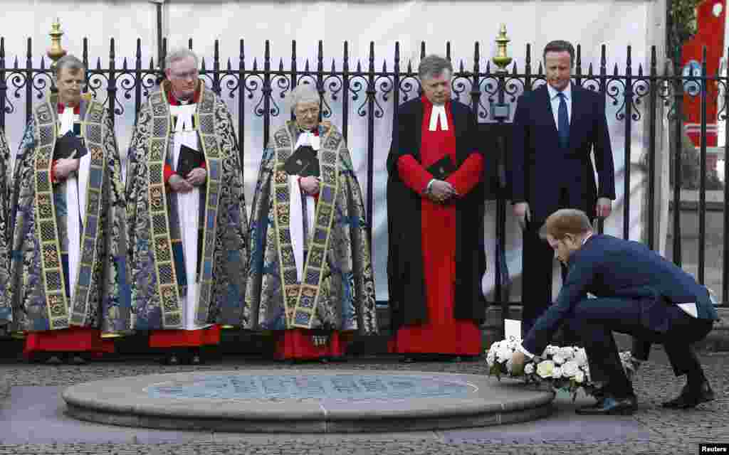 Britain's Prime Minister David Cameron watches as Prince Harry lays a wreath at the memorial service for victims of the attack on the Bardo Museum in Tunis and the Tunisian holiday resort of Port El Kantaoui in Sousse, at Westminster Abbey in central London.
