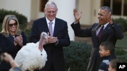 President Barack Obama, with his nephews Aaron Robinson and Austin Robinson and National Turkey Federation Chairman John Reicks, pardons the National Thanksgiving Turkey, Tot, during a ceremony in the Rose Garden of the White House in Washington, Nov. 23, 2016.
