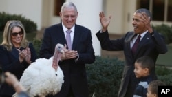 President Barack Obama, with his nephews Aaron Robinson and Austin Robinson and National Turkey Federation Chairman John Reicks, pardons the National Thanksgiving Turkey, Tot, during a ceremony in the Rose Garden of the White House in Washington, Nov. 23, 2016.