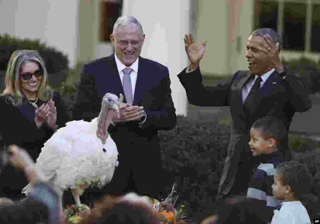 Presiden AS Barack Obama memberikan pengampunan kepada kalkun bernama &quot;Tot&quot; dalam kegiatan tahunan di Gedung Putih, Washington DC, untuk menyambut perayaan Thanksgiving, disaksikan keponakannya Aaron Robinson dan Austin Robinson serta Ketua Federasi Kalkun Nasional John Reicks di Washington (23/11). (AP/Manuel Balce Ceneta)