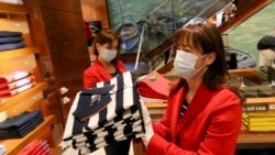 Women with protective masks are preparing to open a store in Vienna, Austria, Tuesday, April 14, 2020.