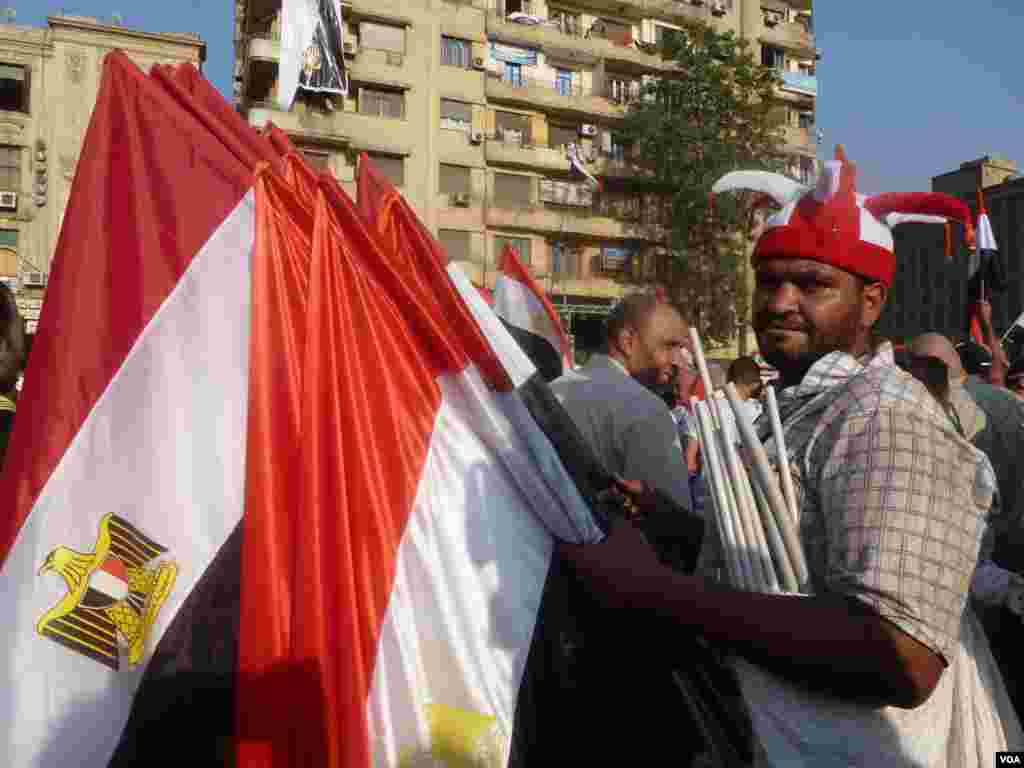 Những cuộc biểu tình phản đối tổng thống Mohamed Morsi và phe ủng hộ nhóm Huynh đệ Hồi giáo khiến doanh thu những mặt hàng cổ động tinh thần dân tộc tăng vọt, từ cờ cho tới áo, 7 tháng 7, 2013. (S. Behn/VOA)