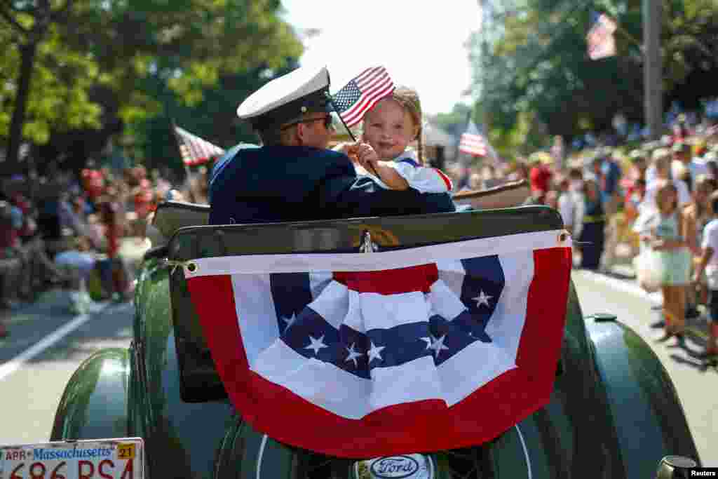 A man and a girl ride in an antique Ford automobile during the annual 4th of July parade in Barnstable Village on Cape Cod, Massachusetts.