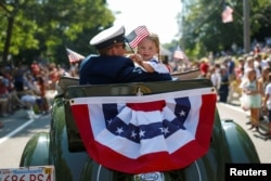 在美国麻萨诸塞州鳕鱼角的国庆游行中，一个男人和一个女孩乘坐古董福特汽车（2019年7月4日）。