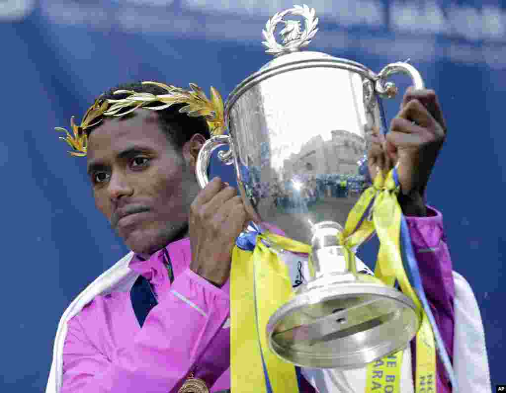 Ethiopian Lelisa Desisa lifts his trophy after winning the Boston Marathon for the second time. Desisa won the marathon two years ago, donating the medal to the city of Boston in memory of the bombing victims, April 20, 2015.