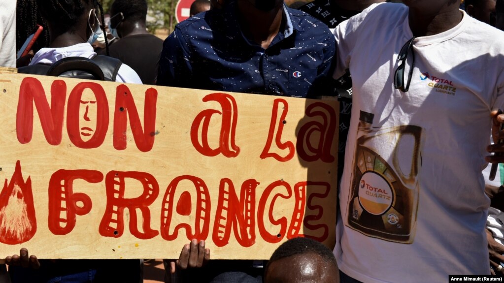 Des manifestants tiennent une pancarte sur laquelle on peut lire 