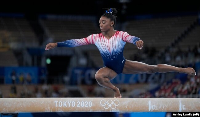 FILE - Simone Biles, of the United States, performs on the balance beam during the artistic gymnastics women's apparatus final at the 2020 Summer Olympics, Tuesday, Aug. 3, 2021, in Tokyo, Japan. (AP Photo/Ashley Landis)