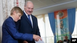 2015年10月11日白俄罗斯总统卢卡申科和他最年轻的儿子在选举站。
