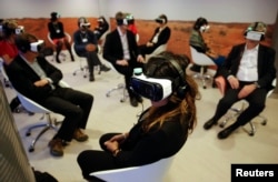 FILE - Participants attend the "Collisions. A Virtual Reality World Premiere" event at the annual meeting of the World Economic Forum (WEF) in Davos, Switzerland, Jan. 21, 2016.