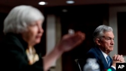 Treasury Secretary Janet Yellen, left, accompanied by Federal Reserve Chairman Jerome Powell, speaks during a Senate Banking Committee hearing on Capitol Hill in Washington, Nov. 30, 2021.