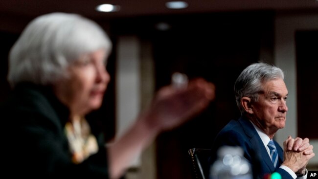 Treasury Secretary Janet Yellen, left, accompanied by Federal Reserve Chairman Jerome Powell, speaks during a Senate Banking Committee hearing on Capitol Hill in Washington, Nov. 30, 2021.