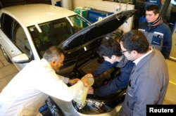 Pakar biokimia Cesar Saez (kiri) melakukan uji coba pada mesin sebuah mobil dengan biofuel yang terbuat dari mikroalga sebagai pengganti mesin diesel untuk mengurangi emisi di Santiago, Chile, 28 Juni 2017.