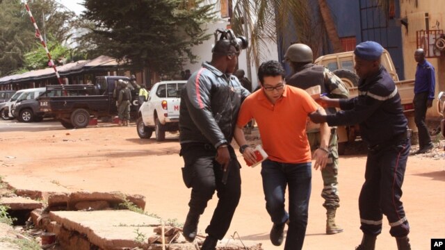 Tropas malienses ayudan a un rehén que se escapó del hotel Radisson Blu atacados por yihadistas aparentemente pertenecientes a un grupo afiliado a al-Qaeda.