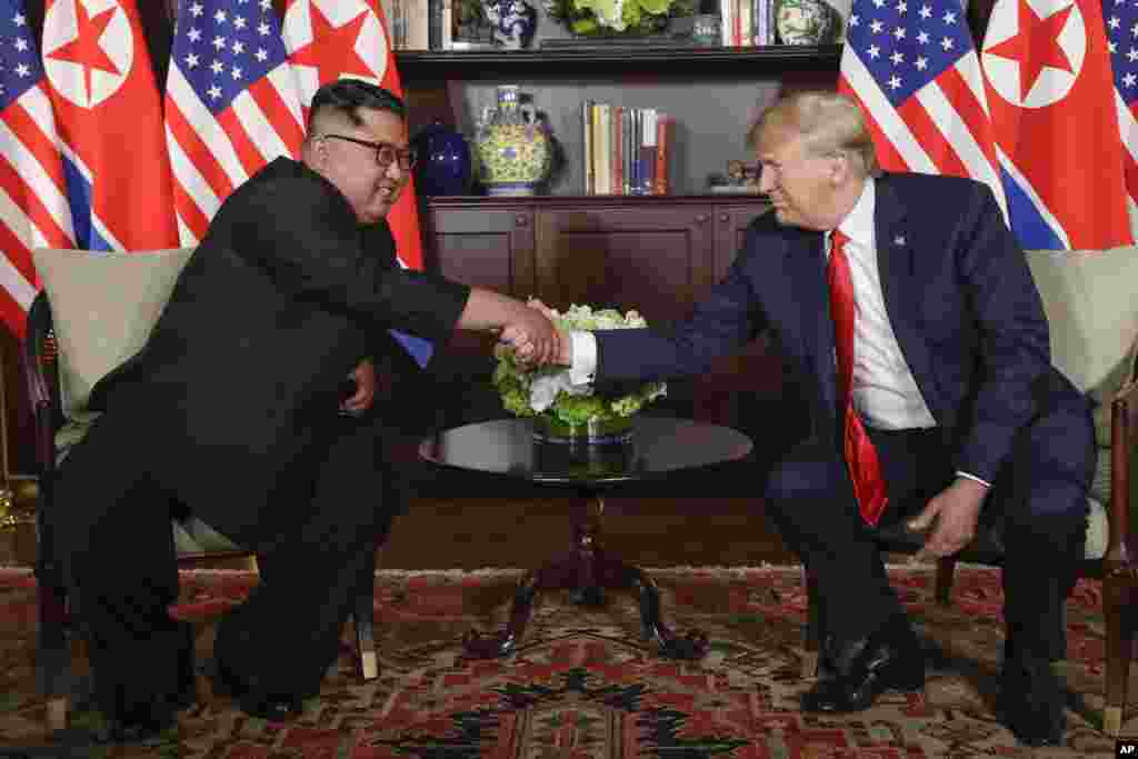 도널드 트럼프 미국 대통령과 김정은 국무위원장이 12일 싱가포르 카펠라 호텔의 단독회담장에 입장한 후 다시 악수를 하고 있다. 두 정상은 사진 촬영 후 비공개로 회담을 진행했다.