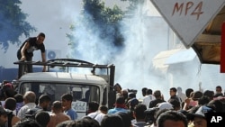 Radical Islamist militants leave as police use tear gas during a demonstration in Tunis, Tunisia, October 14, 2011.