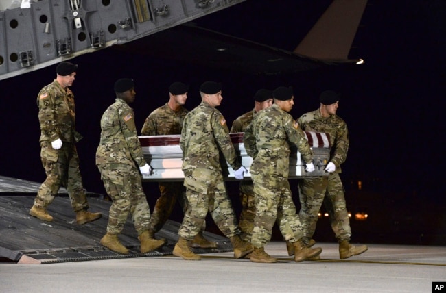 FILE - In this image provided by the U.S. Air Force, a U.S. Army carry team transfers the remains of Army Staff Sgt. Dustin Wright of Lyons, Ga., upon arrival at Dover Air Force Base, Del., Oct. 5, 2017. Four U.S. troops and four Niger forces were killed in an ambush by dozens of Islamic extremists in Niger.