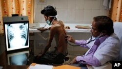 FILE - An Indian doctor examines a tuberculosis patient in a government TB hospital on World Tuberculosis Day in Allahabad, India. 