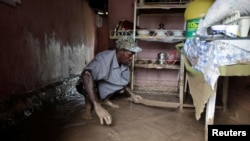 Un homme nettoie sa boutique après l'inondation provoquée par l'ouragan Matthieu à Les Cayes, Haïti, 5 octobre 2016.