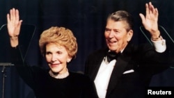 FILE - Former U.S. president Ronald Reagan and his wife Nancy wave while attending a gala celebrating his 83rd birthday, Feb. 3, 1994, in Washington. 