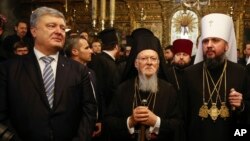 El Patriarca Ecuménico Bartolomé, centro, junto al presidente de Ucrania, Petro Poroshenko, izquierda, y Epifaniy, el jefe de la Iglesia Ucraniana Metropolitana.