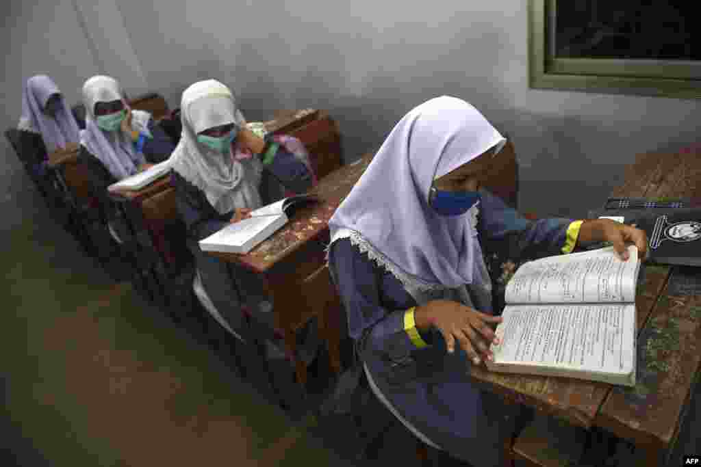 کراچی کے ایک اسکول کی درس گاہ میں ماسک پہنے طالبات پڑھائی میں مصروف ہیں۔