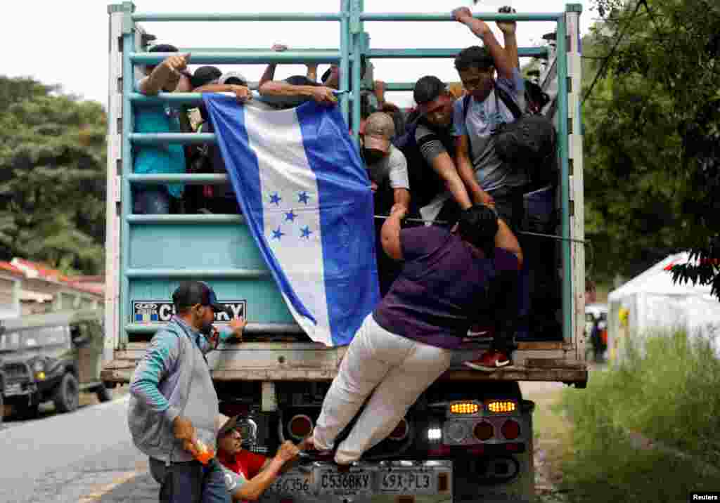 A Honduran migrant, part of a caravan trying to reach the U.S., climbs on a truck in Quezaltepeque, Guatemala, Oct. 16, 2018.