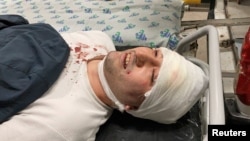 FILE - Blogger Miraziz Bazarov lies on a stretcher upon his arrival at a hospital after he was beaten by a group of unidentified men in Tashkent, Uzbekistan March 29, 2021.