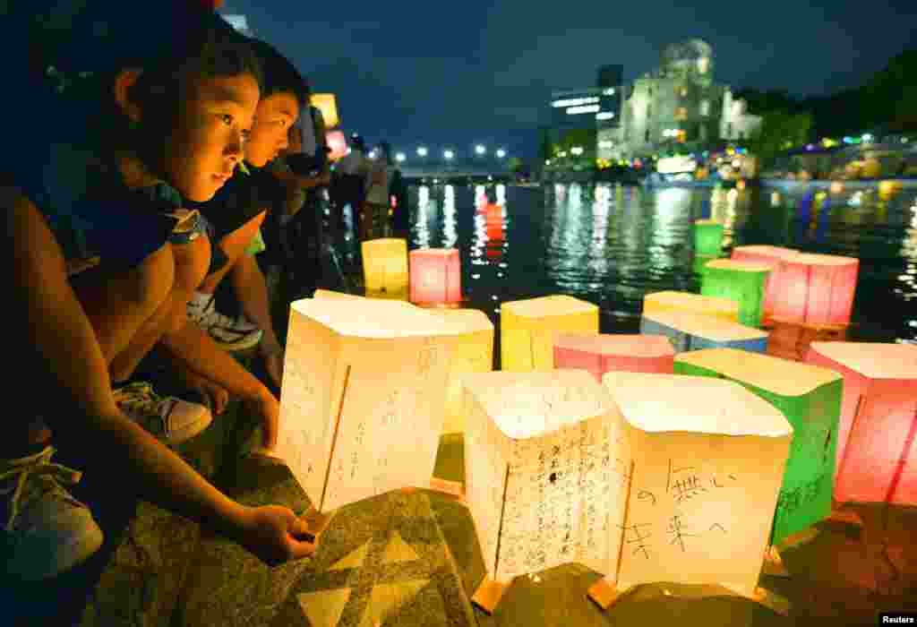 为纪念广岛核爆炸69周年，当地居民在本康河畔放孔明灯。