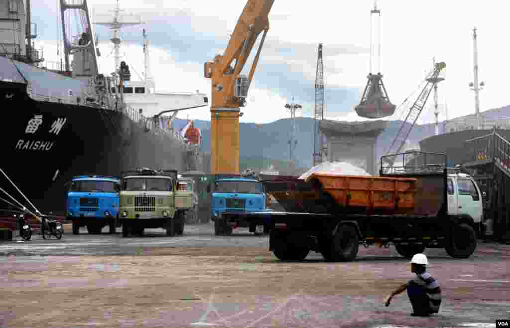 Pekerja Vietnam mengamati Pelabuhan Cam Ranh yang sibuk. (D. Schearf/VOA)