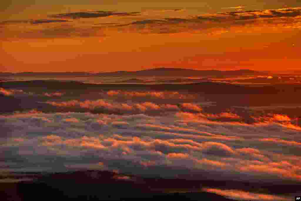 Valley fog, caused by cool air flowing over moist land, drifts across Oxford County in this view at dawn looking east over Lovell, Maine.