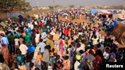 Displaced people walk around Tomping camp in Juba, where some 15,000 people who fled their homes are sheltered by the United Nations, Jan. 7, 2014. 