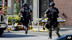 Seattle Police run toward a campus building following a shooting at Seattle Pacific University, June 5, 2014.