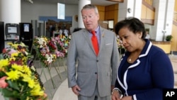 Orlando Mayor Buddy Dyer, left, and Attorney General Loretta Lynch view a memorial with 49 wreaths at City Hall, one wreath for each victim of the Pulse nightclub mass shooting in Orlando, Florida, June 21, 2016. 