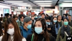 香港一地铁站里的乘客多戴上口罩以防止感染武汉肺炎。（2020年1月22日）