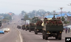FILE - Congo military trucks carrying Congolese troops drive in a main street after violence erupted due to the delay of the presidential elections in Kinshasa, Democratic Republic of the Congo, Sept. 20, 2016.