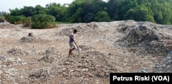 Seorang warga sedang memilah sampah plastik di lahan bekas sawah di Desa Bangun, Kabupaten Mojokerto, 19 Juni 2019. (Foto: Petrus Riski/VOA)