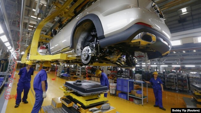 FILE - A battery is about to be installed on a electric car at a BYD assembly line in Shenzhen, China May 25, 2016. (REUTERS/Bobby Yip)