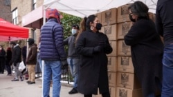 Volunteer Gloria Martinez, left, speaks with Sofia Moncayo, who runs a food distribution program through Mosaic West Queens Church in the Sunnyside neighborhood of the Queens borough of New York on Monday, Feb. 22, 2021. (AP Photo/Emily Leshner)