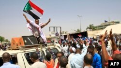 Sudanese protesters, waving national flags, take part in a sit-in outside the army headquarters in Khartoum, May 5, 2019.
